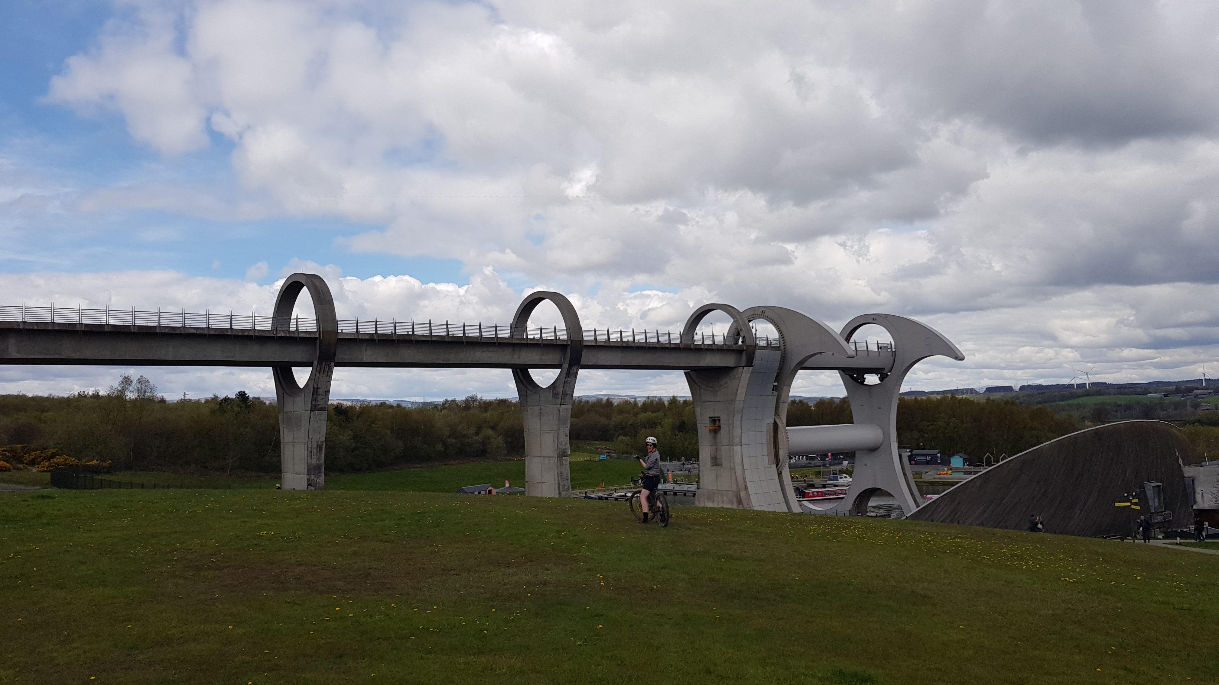 A photo of Kara, on her bike, in front of the Falkirk Wheel.