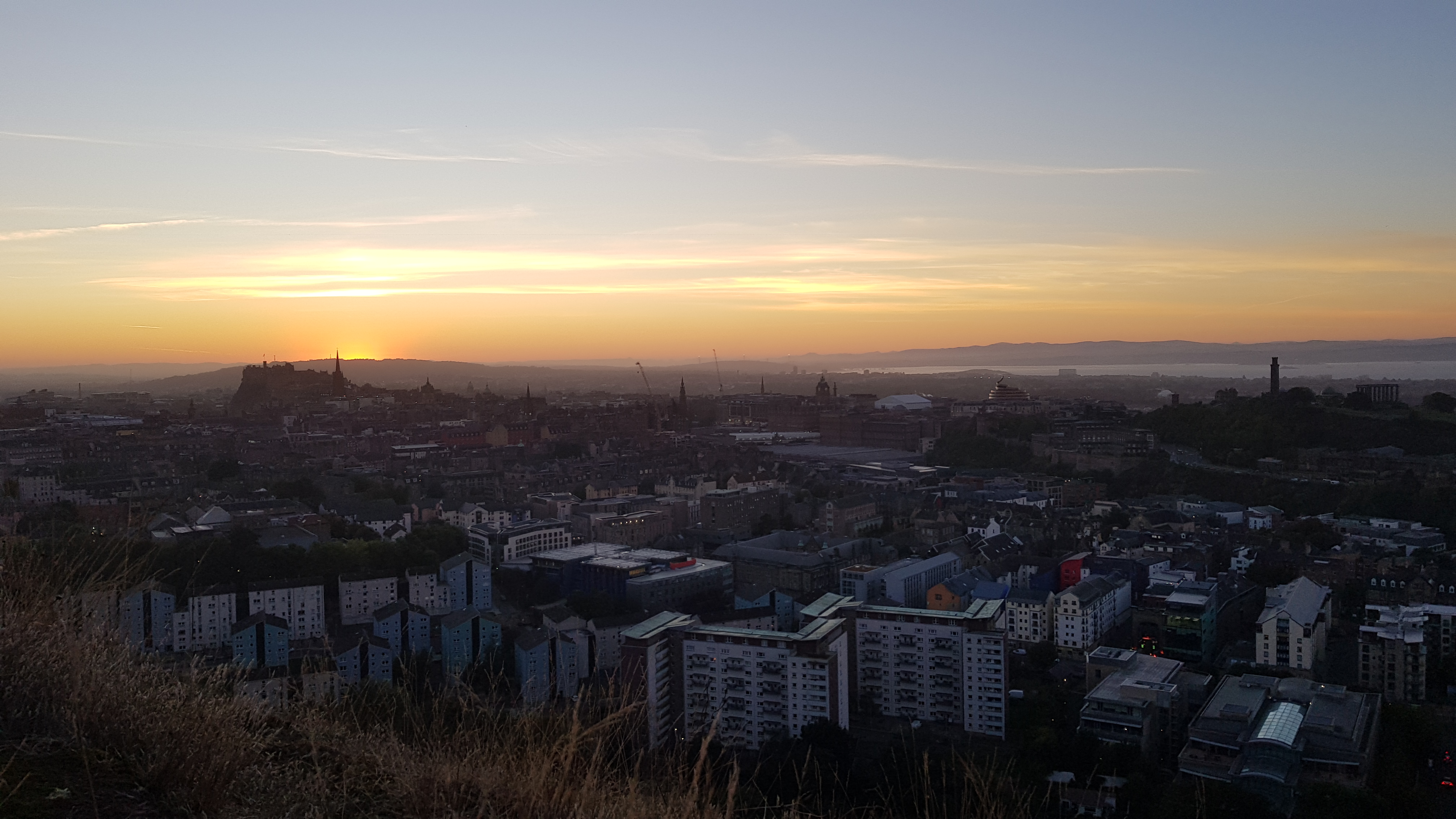 A photograph of the sun setting over Edinburgh, captured from atop Salisbury Crags in September.